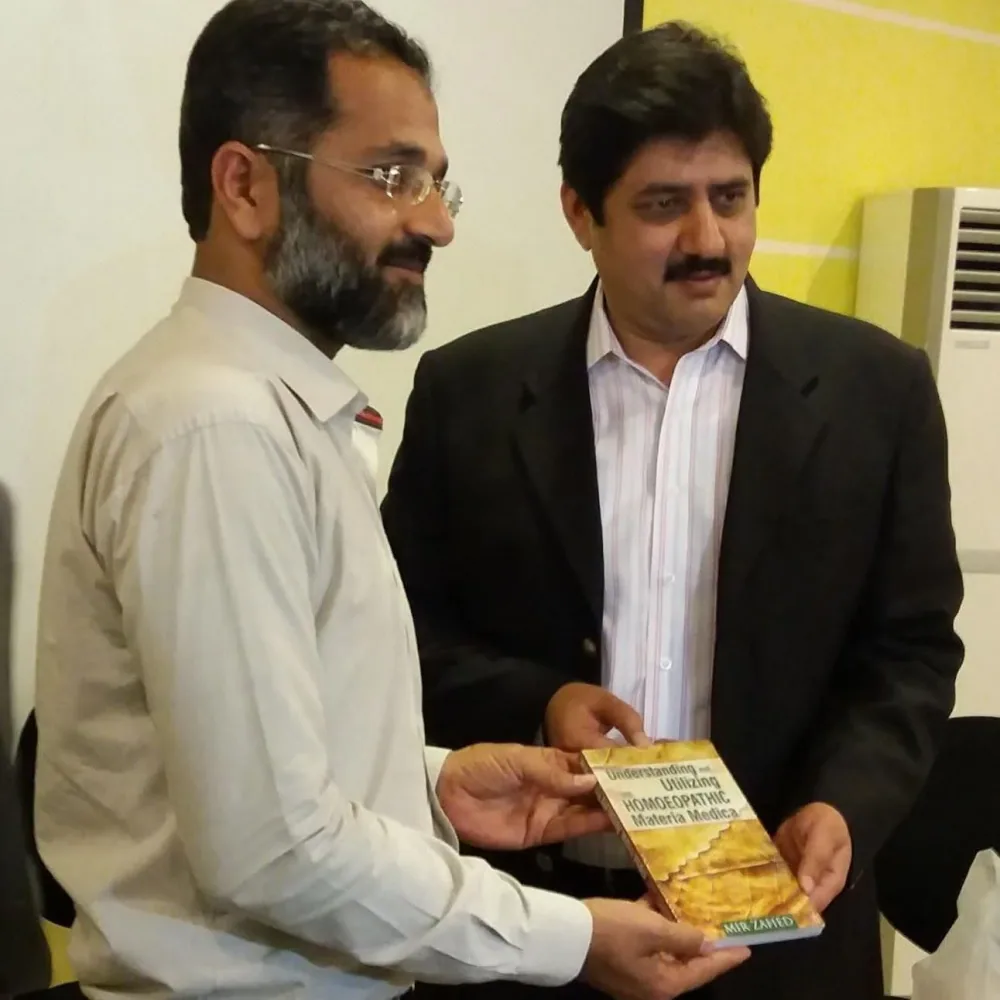 Dr. Mir Zahed presenting a copy of the book to Dr. M. Zubair Qureshi.
